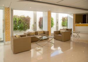 a living room with couches and tables and windows at Zip By Spree Hotels Samudra Belgaum in Belgaum