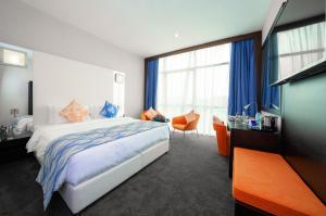 een slaapkamer met een bed en een groot raam bij Ramada Encore Doha by Wyndham in Doha
