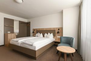 1 dormitorio con 1 cama, 1 mesa y 1 silla en Landschloss Korntal en Korntal-Münchingen