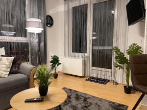 a living room with a couch and a table with plants at Európa 20 Apartman in Bük