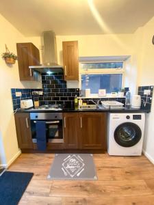 a kitchen with a stove and a washing machine at SwankyHome 4 Groups/Contractors in Birmingham