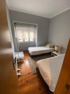 a small bedroom with two beds and a window at Belem Aloja in Lisbon