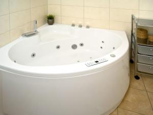 a large white bath tub in a bathroom at Dänische Ferienhäuser am Salzhaff Haus Poseidon in Insel Poel +20 photos