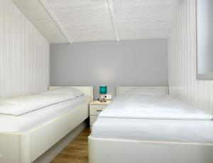 two beds in a room with white walls at Dänische Ferienhäuser am Salzhaff Haus Poseidon in Insel Poel