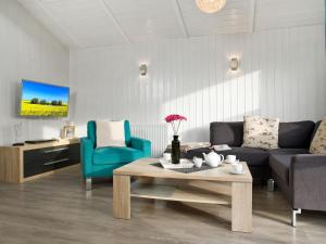 a living room with a couch and a table and chairs at Dänische Ferienhäuser am Salzhaff Haus Poseidon in Insel Poel