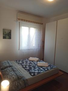 a bed in a room with a window at Stanza Maggiore in Parma