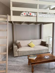 - un salon avec un canapé et des lits superposés dans l'établissement Maupiti, au Tréport