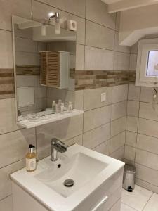 La salle de bains blanche est pourvue d'un lavabo et d'un miroir. dans l'établissement Maupiti, au Tréport