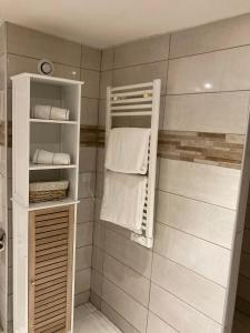 La salle de bains est pourvue d'une douche et de serviettes blanches. dans l'établissement Maupiti, au Tréport
