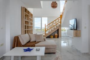 a living room with a couch and a table at Villas Lago e Mare in Skála Alykís