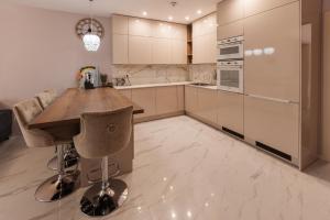 een keuken met een houten tafel en een aantal stoelen bij Beverly Hills House pri potoku by Pinkreal in Solčany