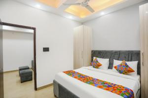 een slaapkamer met een groot wit bed met kleurrijke kussens bij FabHotel Rasa Arcade in Ghaziabad