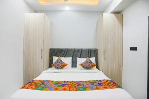 een slaapkamer met een bed met een houten hoofdeinde bij FabHotel Rasa Arcade in Ghaziabad