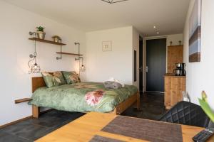 a bedroom with a bed in a room with a table at Johanneshoeve - de mooiste plek op Texel in Den Hoorn