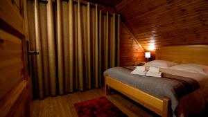 ein Schlafzimmer mit einem Bett in einer Holzhütte in der Unterkunft Chalé | Penhas da Saúde - Serra da Estrela in Penhas da Saúde