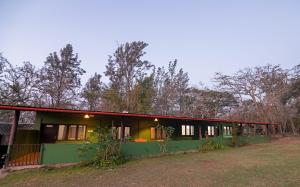a green house with a red roof at Bamboo Banks Farm & Guest House in Masinagudi