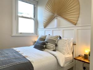 a bedroom with a bed with pillows and a fan at Stunning Beach Themed 2 Bed Apartment in Bournemouth