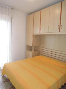 Schlafzimmer mit einem Bett mit Schränken und einem Fenster in der Unterkunft Flat with terrace near the beach - Beahost in Bibione