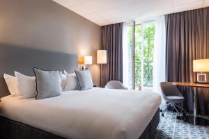 a hotel room with a large bed and a window at Crowne Plaza Paris R&eacute;publique, an IHG Hotel in Paris