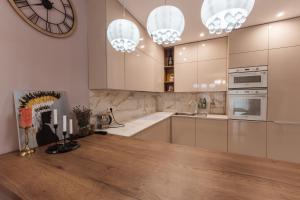 een keuken met witte kasten en een grote klok aan de muur bij Beverly Hills House pri potoku by Pinkreal in Solčany +37 foto's
