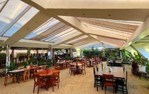Piña Colina Resort في تاجيتاي: مطعم بطاولات وكراسي خشبية ونوافذ