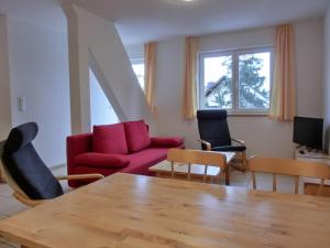 a living room with a red couch and chairs at Ferienwohnung NH14 in Hirschburg
