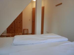 a white bed in a room with a staircase at Ferienwohnung NH14 in Hirschburg