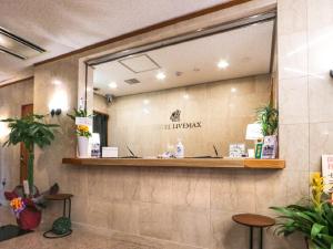 einen Spiegel an der Wand einer Krankenhauslobby in der Unterkunft HOTEL LiVEMAX BUDGET Fuji Ekimae in Fuji