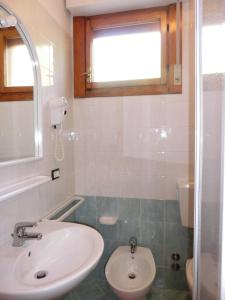 ein Bad mit einem Waschbecken und einem WC in der Unterkunft Loving apartment with garden view - Beahost in Bibione