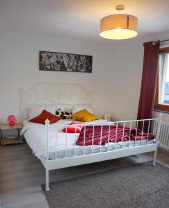 Un dormitorio con una cama blanca con almohadas rojas y amarillas en Nr 1 Apartment with 2 Balconies 3 Bedrooms Near Main Train Station en Viena