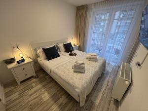 een slaapkamer met een bed met twee handdoeken erop bij Le Normandy 5star in Cadzand