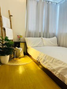 a bedroom with a bed and a potted plant at Minimalist cozy 1BR unit near BGC and McKinley Hill in Manila