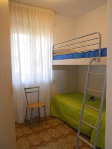 - une chambre avec des lits superposés, une échelle et une chaise dans l'établissement Bright flat with a wide terrace - Beahost Rentals, à Bibione