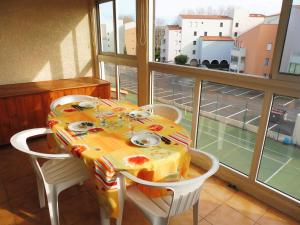 uma mesa de jantar com cadeiras e vista para a cidade em NAUTICAP Joli T2 alcôve piscine tennis NAUTICAP Plage Richelieu cap d'Agde em Cap d'Agde
