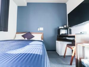 een hotelkamer met een bed en een bureau bij HOTEL LiVEMAX Machida-Ekimae in Machida