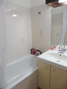 uma casa de banho com uma banheira branca e um lavatório. em NAUTICAP Joli T2 alcôve piscine tennis NAUTICAP Plage Richelieu cap d'Agde em Cap d'Agde