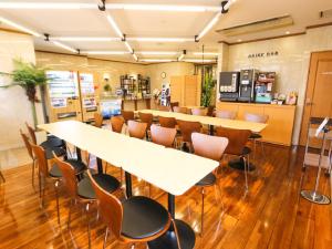 a restaurant with tables and chairs and a counter at HOTEL LiVEMAX BUDGET Fuji Ekimae in Fuji
