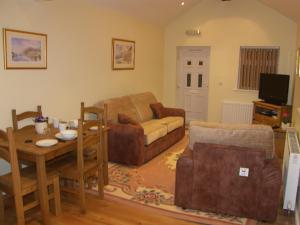 a living room with a couch and a table at Pinfold Holiday Cottage in Laxey