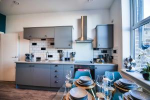 a kitchen with a glass table and blue chairs at Apartment 3 - The Crescent in York