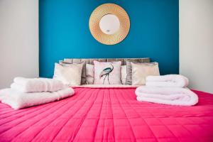 a bedroom with a pink bed with towels on it at Apartment 3 - The Crescent in York