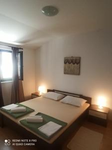 a bedroom with a bed with two lamps on it at Apartments Višnja in Pag