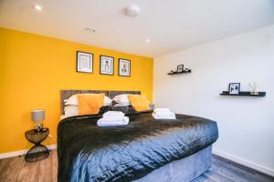 sypialnia z dużym łóżkiem z żółtymi ścianami w obiekcie Apartment 1 - The Crescent w mieście York