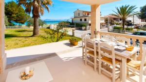 una mesa de comedor blanca en un balcón con vistas al océano en Sun of the Bay BL3 - Bajos A, en Alcudia