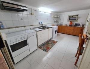 a white kitchen with a sink and a dishwasher at Capogallo47 in Mondello