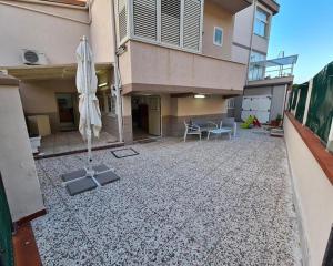 a patio with an umbrella and a table and a chair at Capogallo47 in Mondello