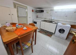 a kitchen with a table and a washing machine at Capogallo47 in Mondello +2 photos