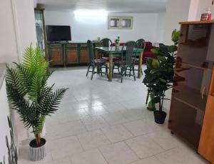 sala de estar con mesa, sillas y plantas en Capogallo47 en Mondello