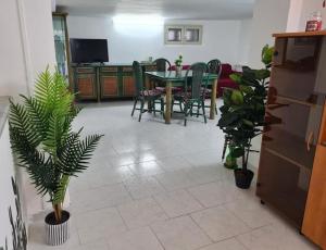 a living room with a table and chairs and plants at Capogallo47 in Mondello