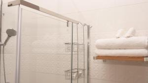 un bagno con doccia e porta posteriore in vetro per la doccia di The Clarice House a Kisumu