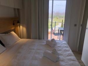 een slaapkamer met een bed met handdoeken erop bij Green Village - Sirenetta in Savigliano